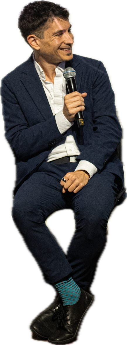 Matthew David Segall seated, holding a microphone